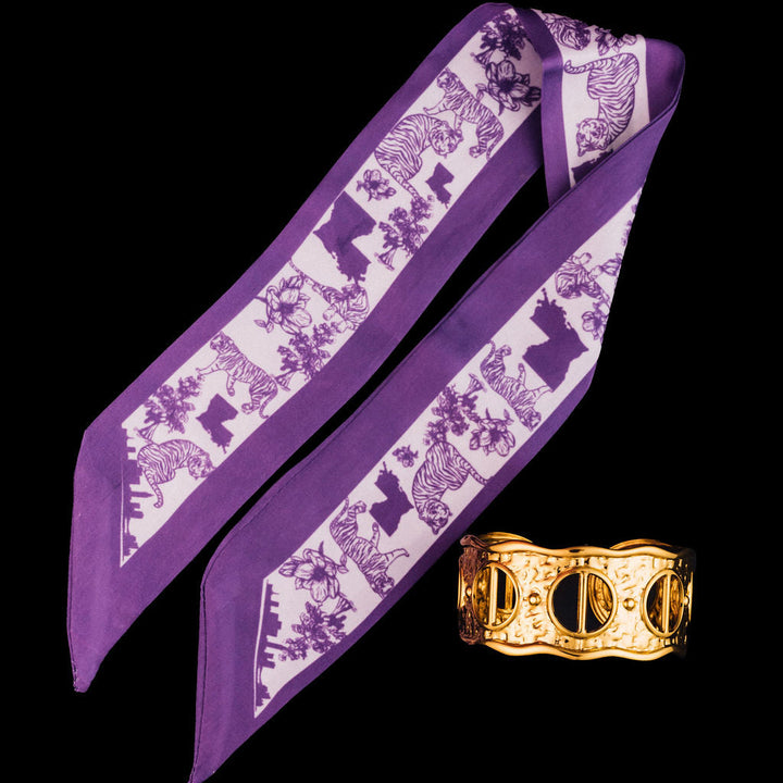 Purple scarf with lilac pattern and gold cuff on black background
