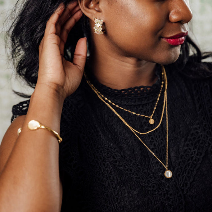 Iridescent flower hoop earrings on figure