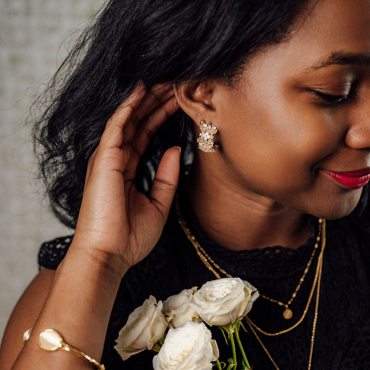 Iridescent flower hoop earrings on figure