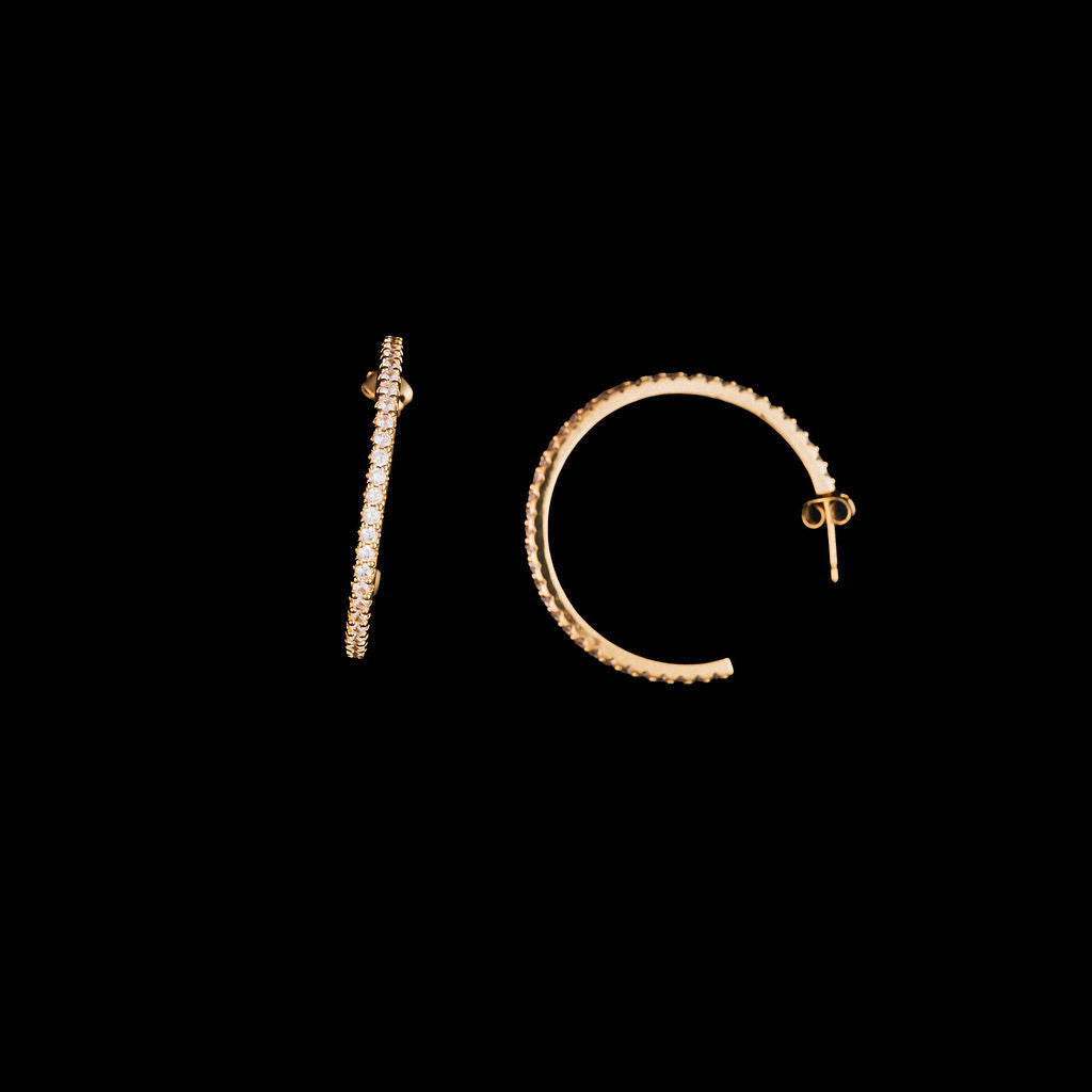 Gold hoop earrings on a black background