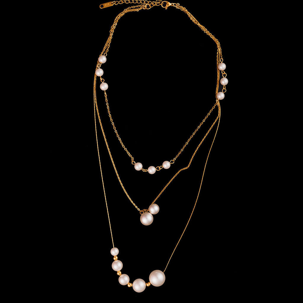 Set of layered pearl necklaces on a black background