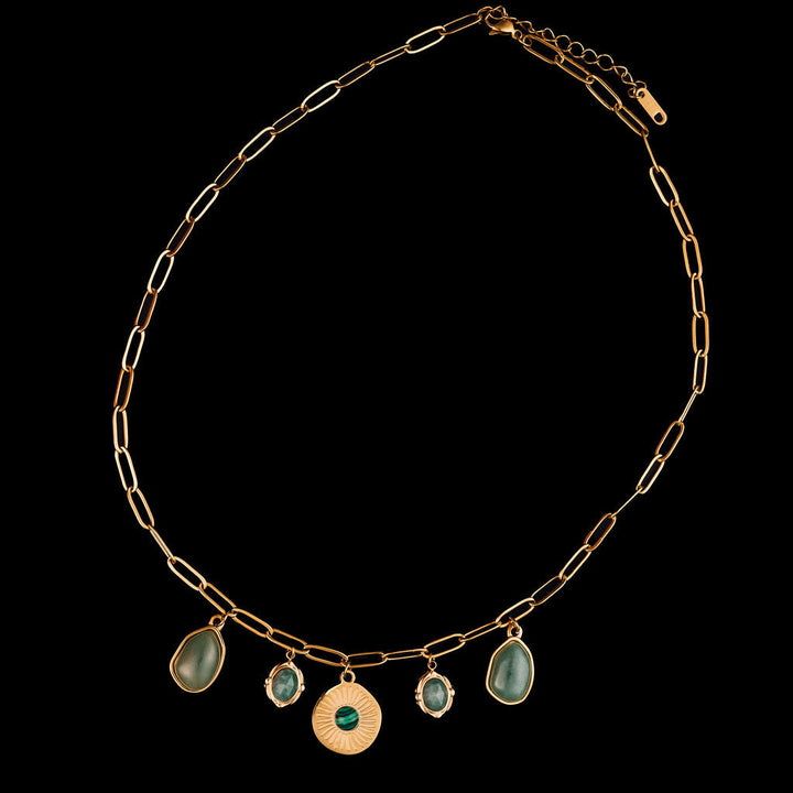 Gold chain necklace with green gemstone pendants on a black background