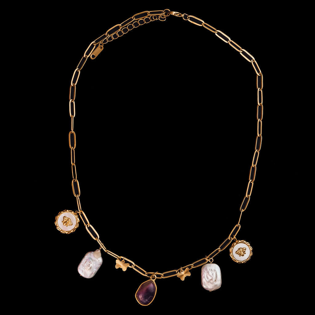 Gold chain necklace with various gemstones on a black background