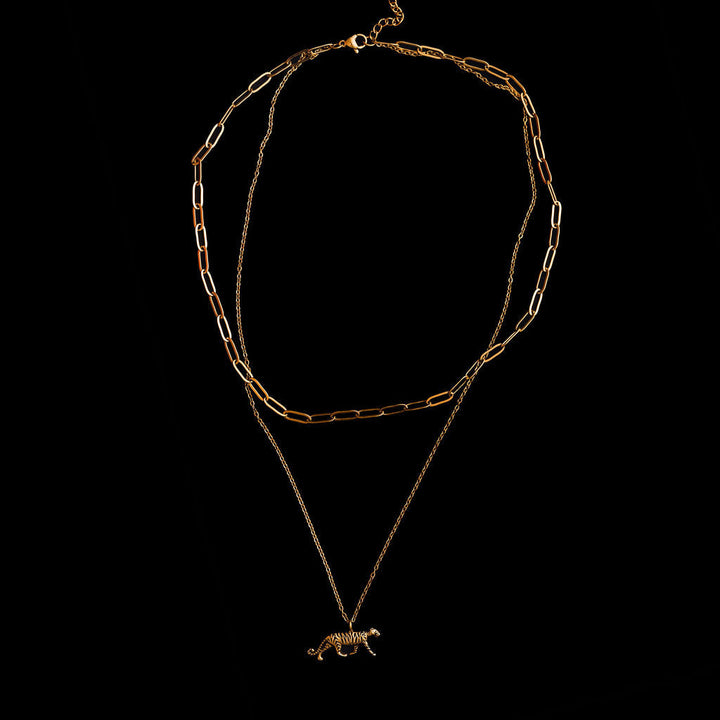 Gold chain necklace with a  tiger pendant on a black background