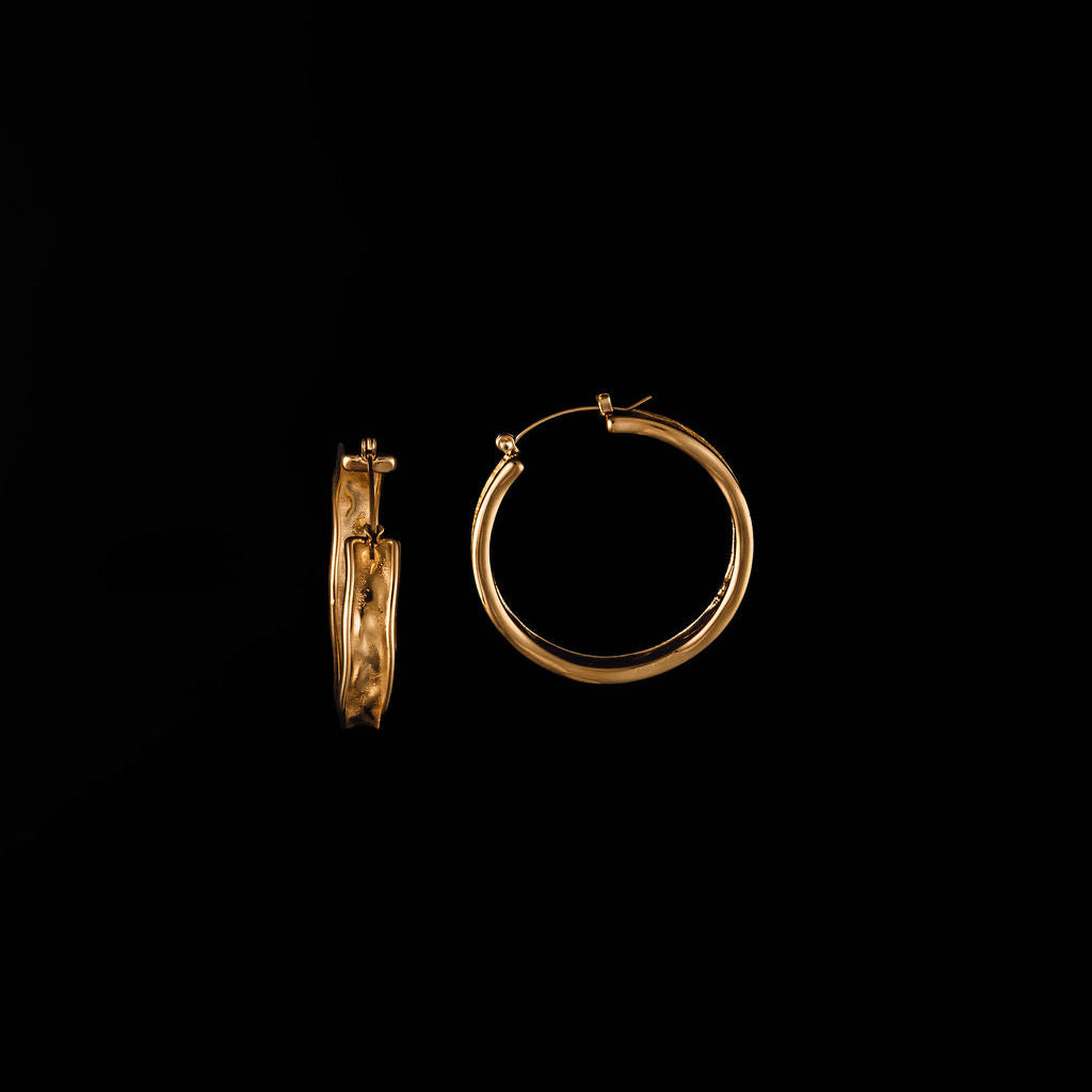 Gold hoop earrings on a black background