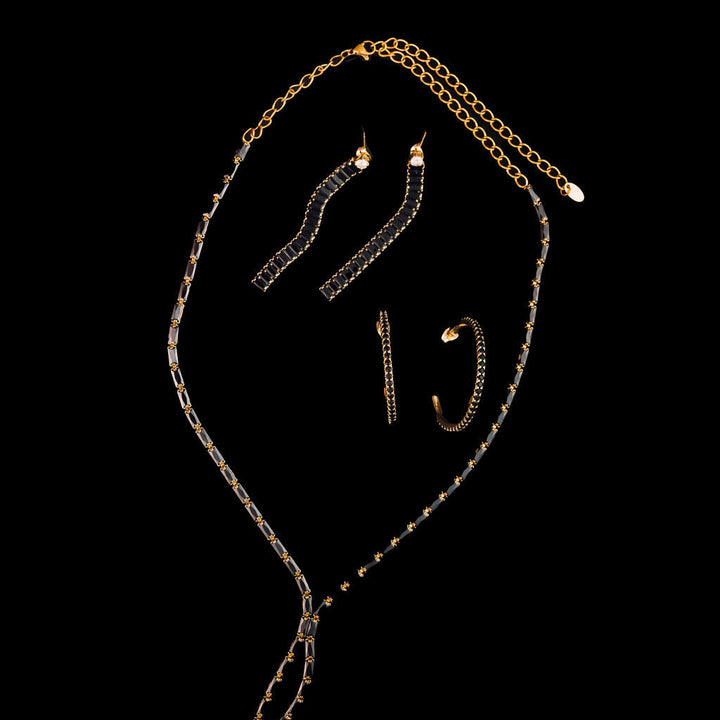 Gold and black chain necklaces on a black background
