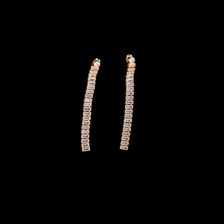Pair of gold hoop earrings on a black background