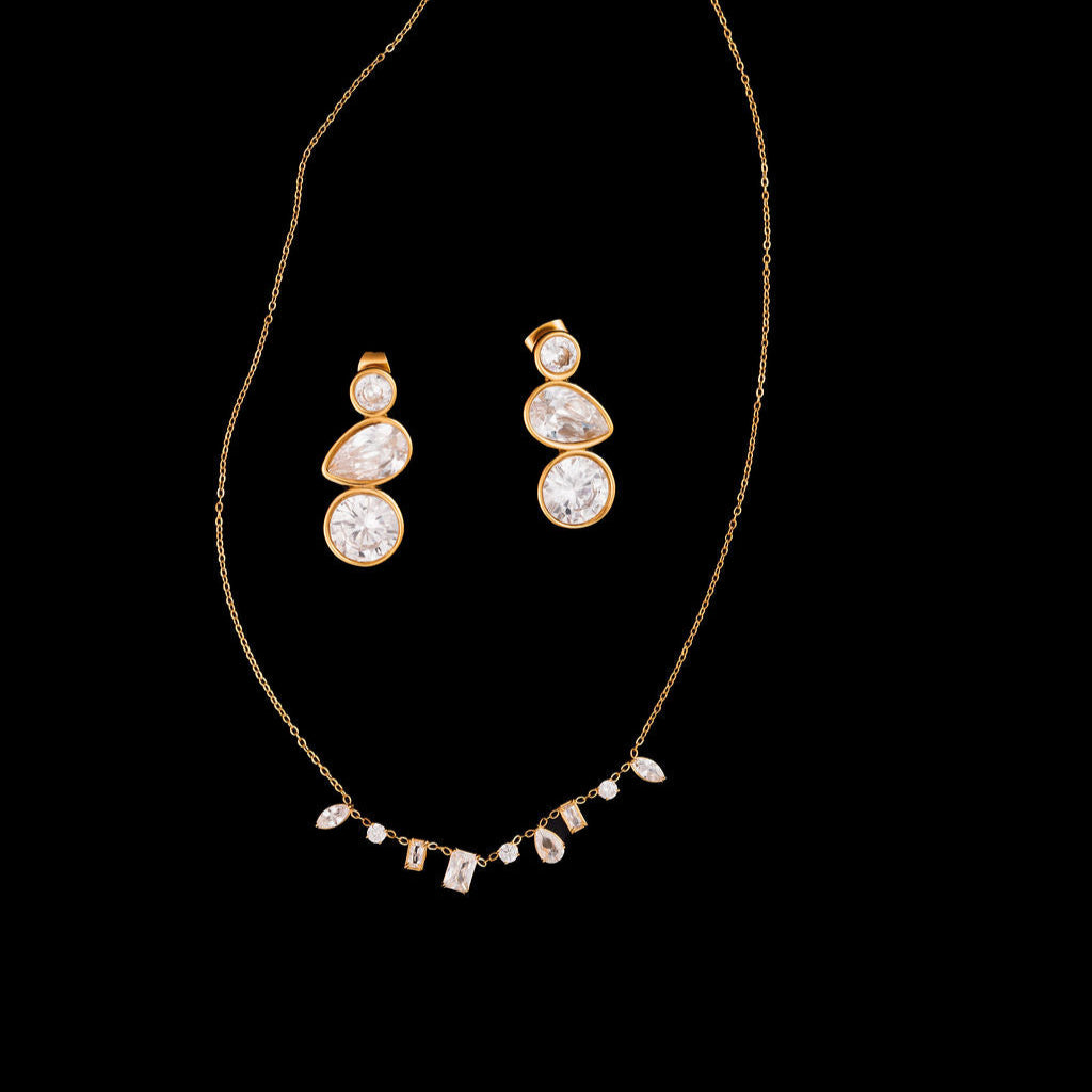 Gold necklace with matching earrings on a black background