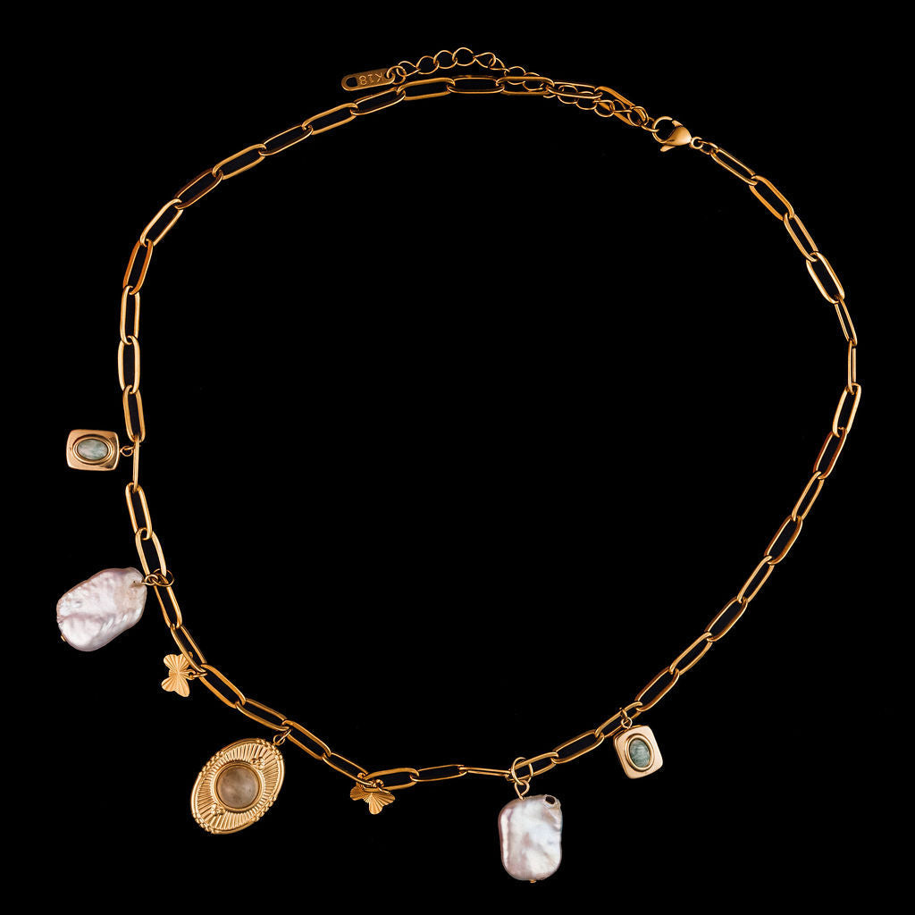 Gold necklace with various pendants on a black background
