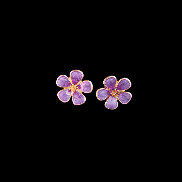 Purple daisy flower-shaped earrings on a black background