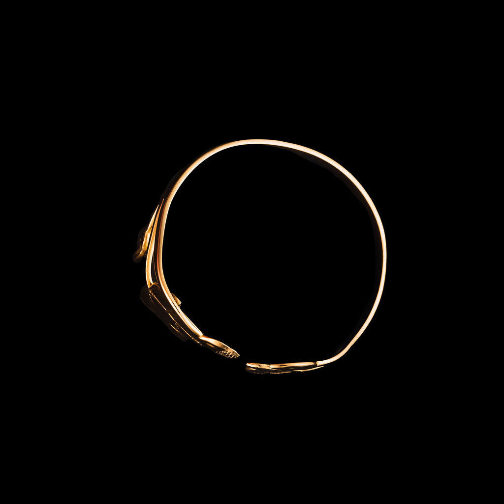 Gold magnolia cuff on a black background