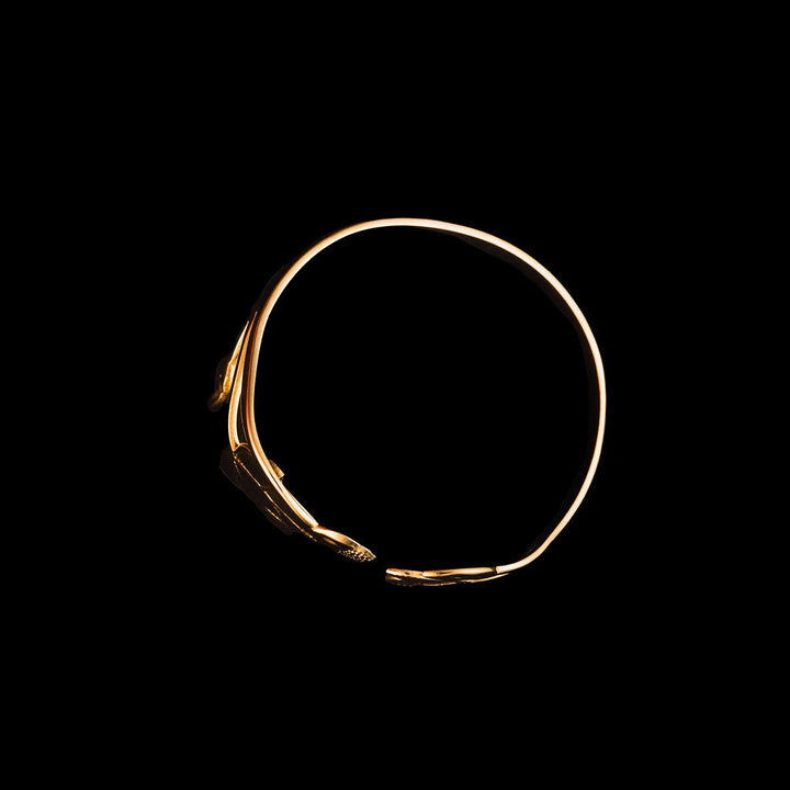 Gold magnolia cuff on a black background